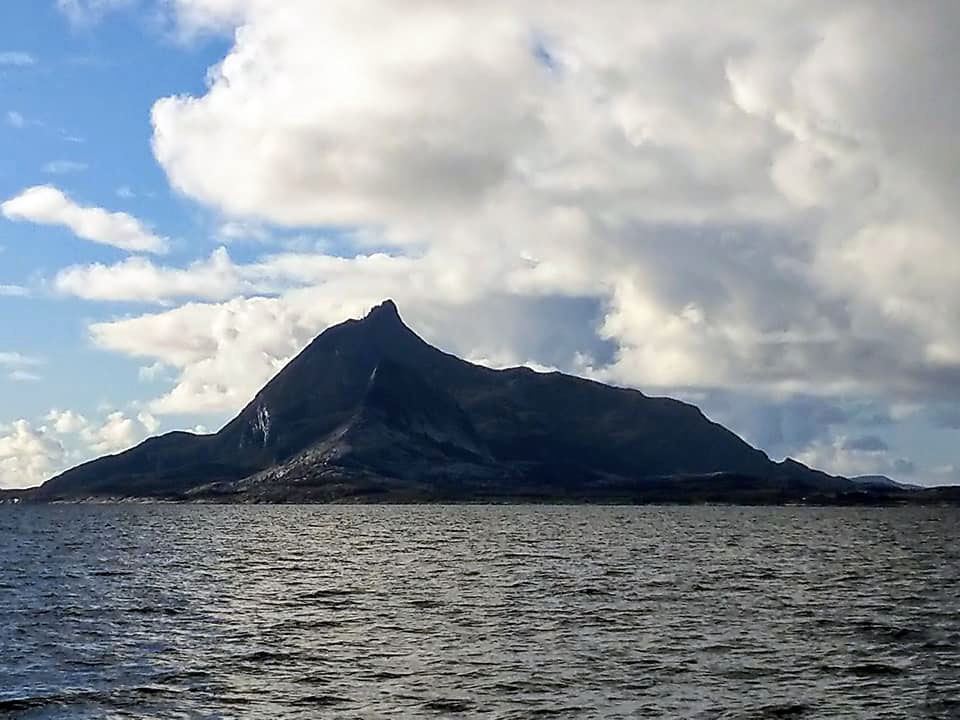 A big mountain with sea in front.