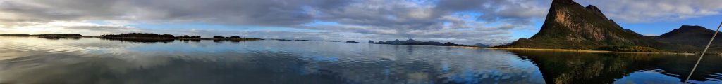 A wide lens view of the still waters and big mountains.