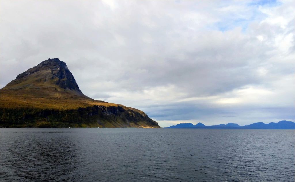 A huge, pointed mountain sloping into the water.