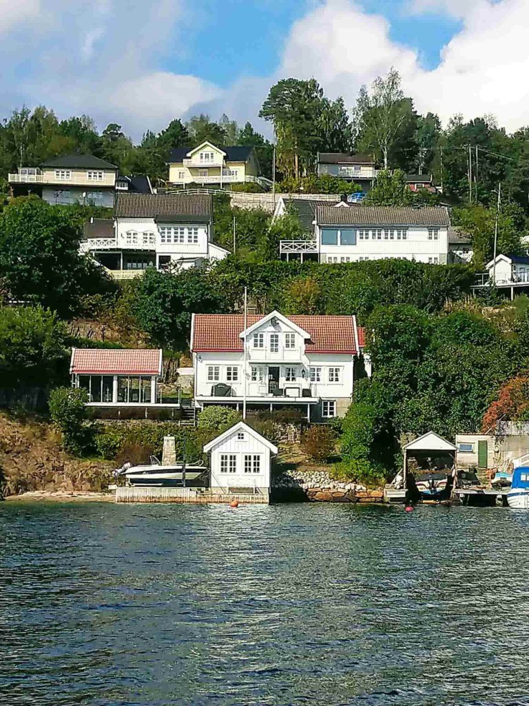 White houses on a hill near the water.