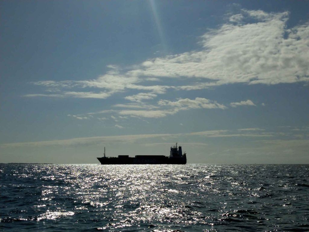 The silhouette of a huge ship on the water.