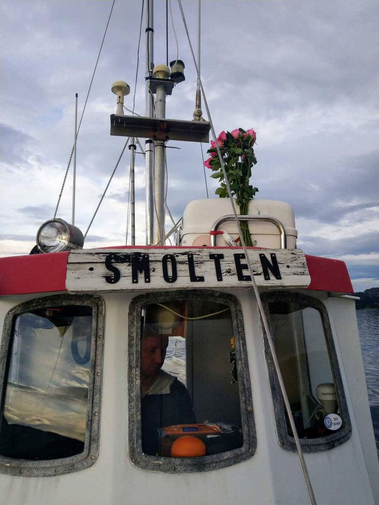 The wheelhouse of Smolten with a  bouquet of roses on the roof.