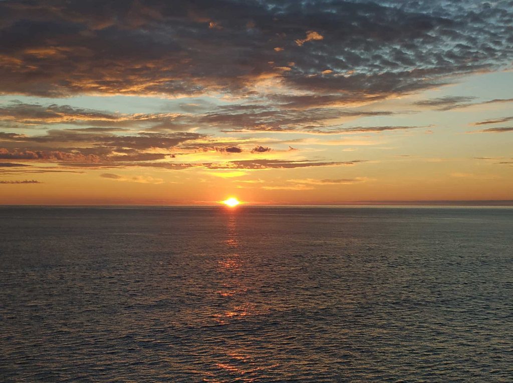 A bright, orange sunset over the ocean.